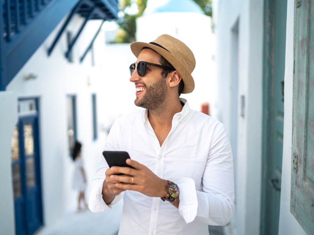 man in a hat looking at his cell phone