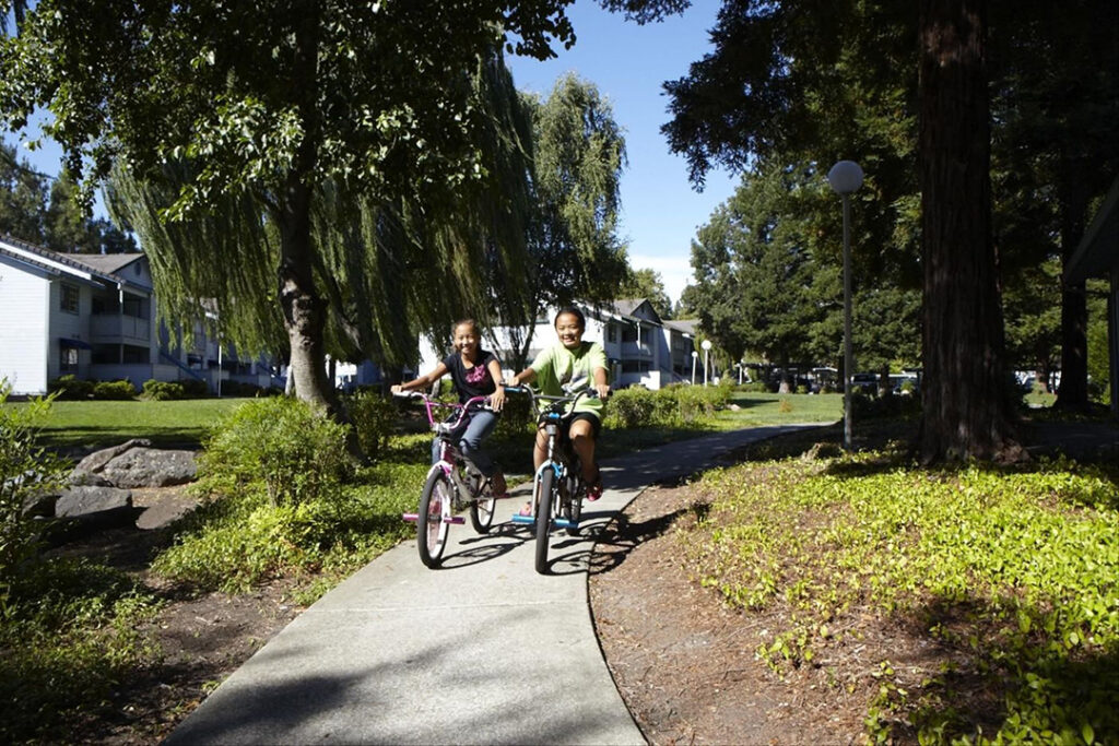 Two girls riding bikes on bike path at Country Brook