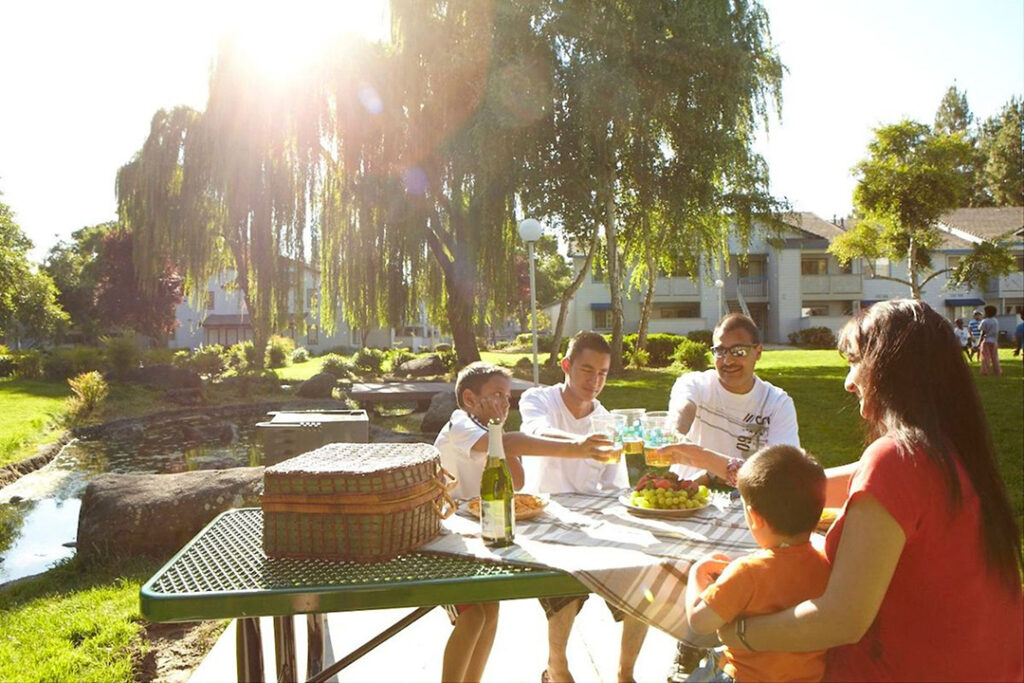 Family outside having picnic at table ouside Country Brook Rental Condominiums